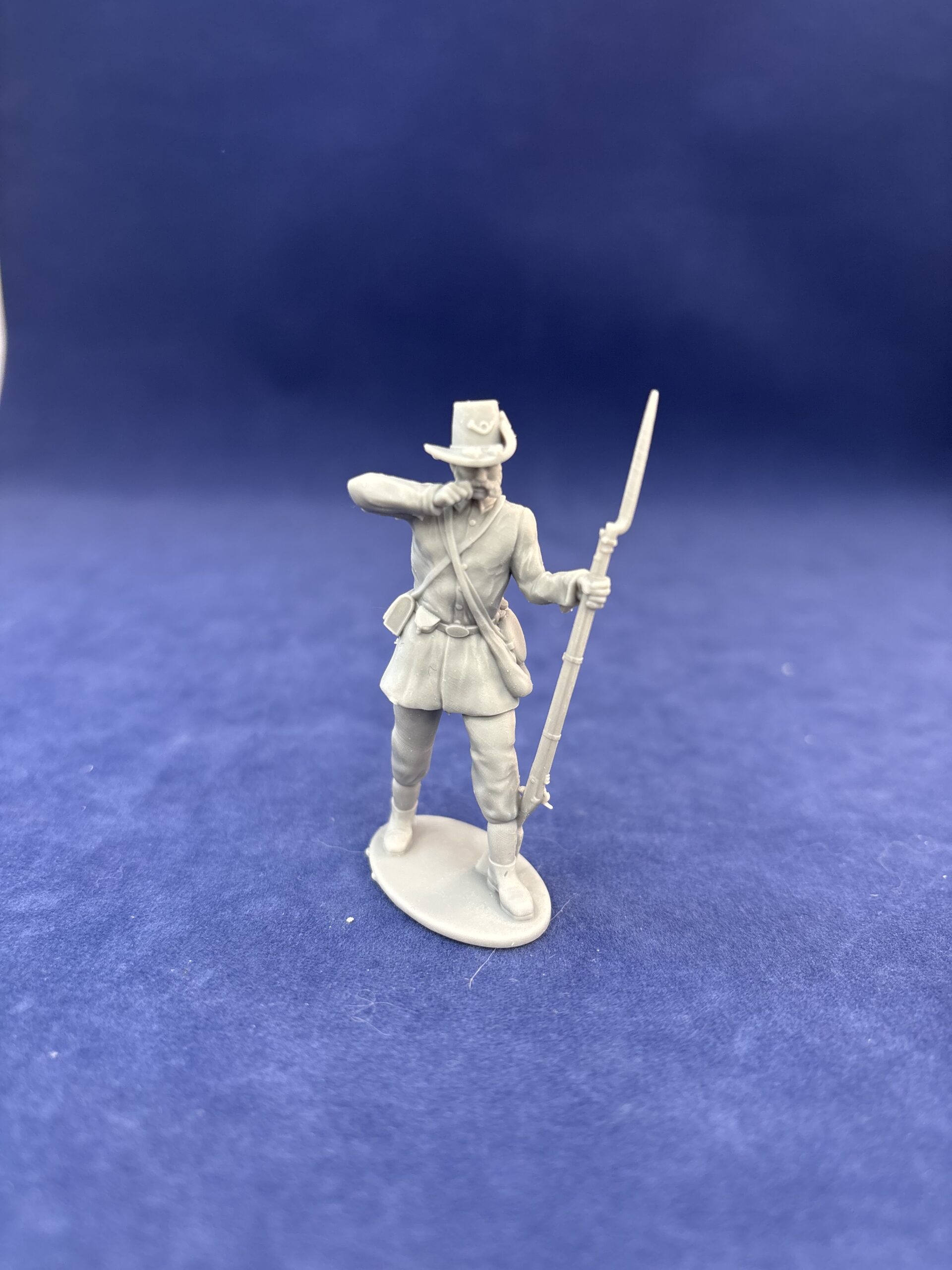 Soldier in hardee hat tearing cartridge in long jacket and kepi, mutton chop sideburns Mustache