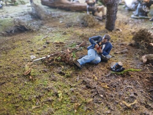 Wounded man checking injury, Union soldier photo review